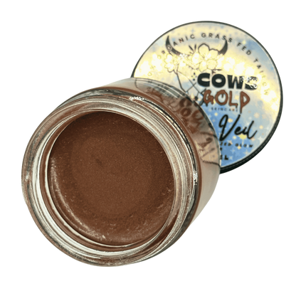 Jar of brown cream with a decorative lid on a green background
